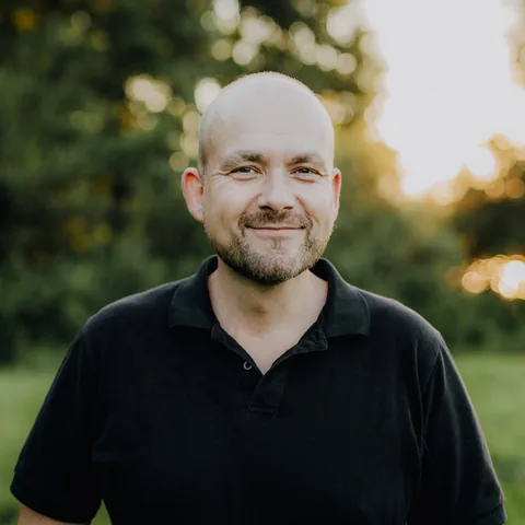 Tim Abing, lächelnd im schwarzen Polo